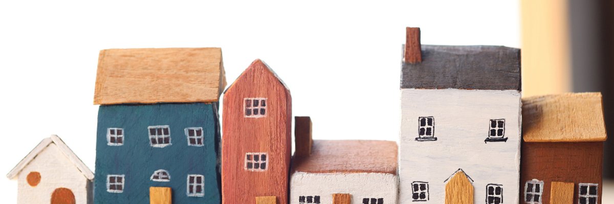 Symbolbild: Foto einer kleinen bunten Häuserzeile, gebastelt aus Holz